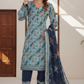 Woman wearing a blue floral traditional outfit with a matching dupatta in a well-lit room.